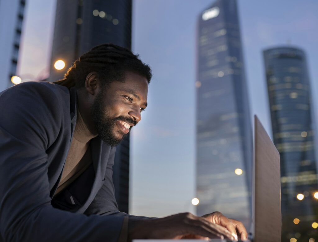 businessman with laptop at night buildings
